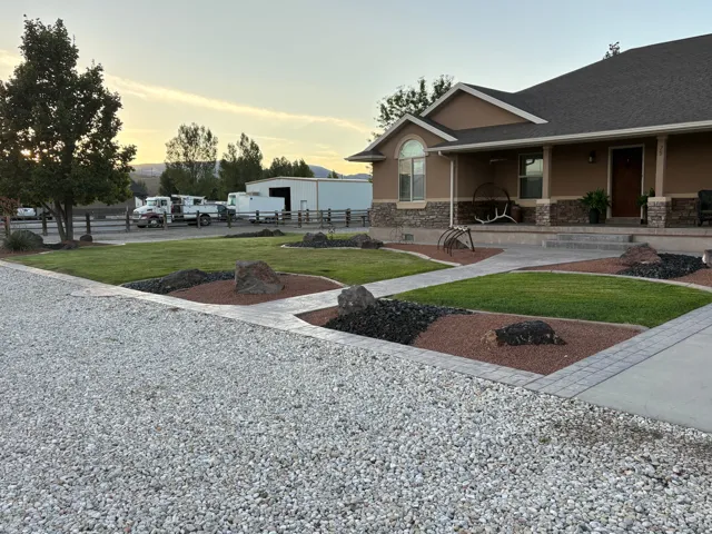 Stucco exterior with stone accenting, covered front porch, and gravel driveway