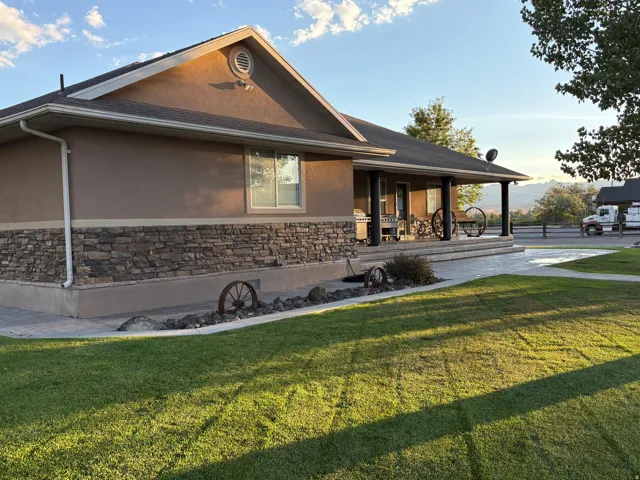 Stucco and stone facade with a covered porch, leading to an expansive concrete patio