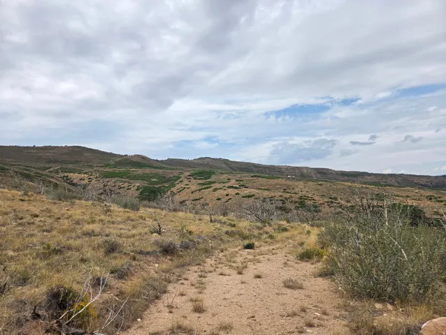 Expansive natural landscape featuring rolling hills, distant mountains, and a beautiful view!