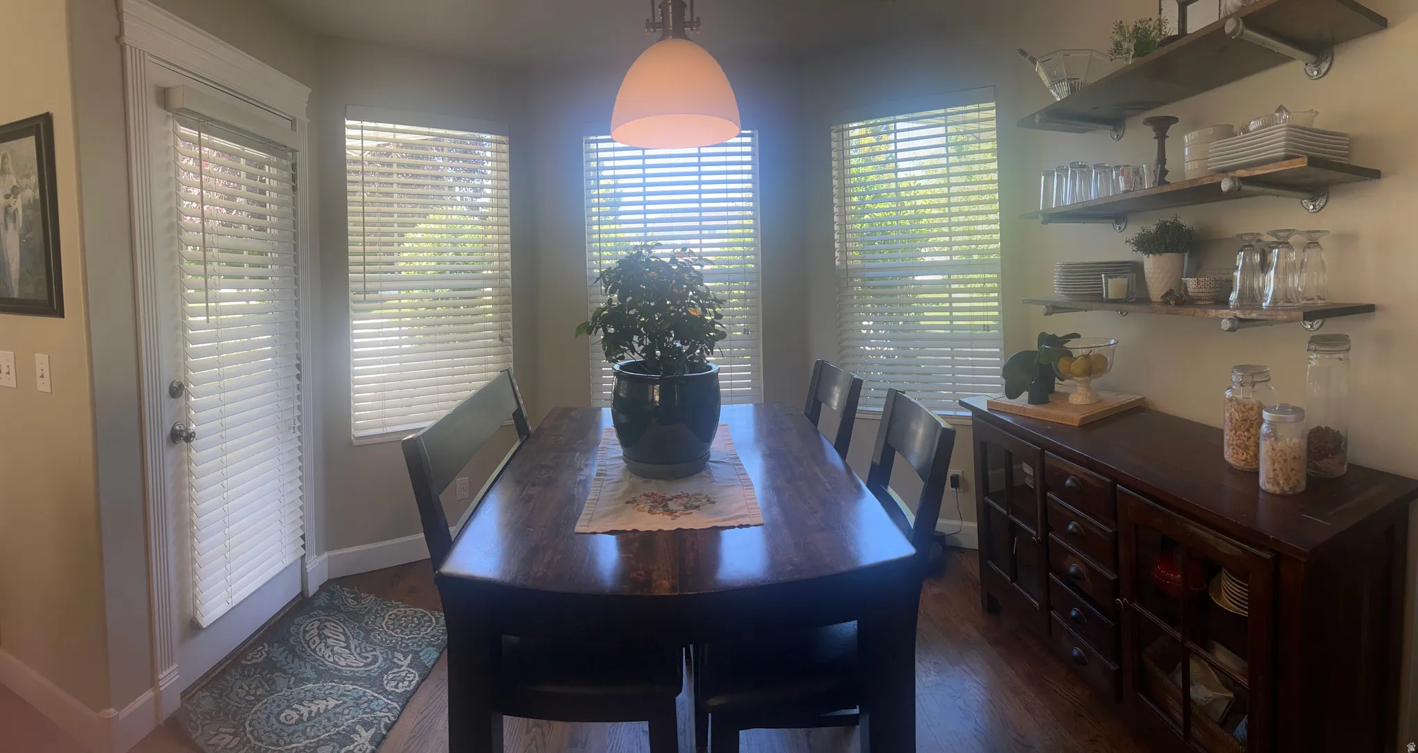 Dining area with multiple windows, a door with a window, and wood-finish flooring