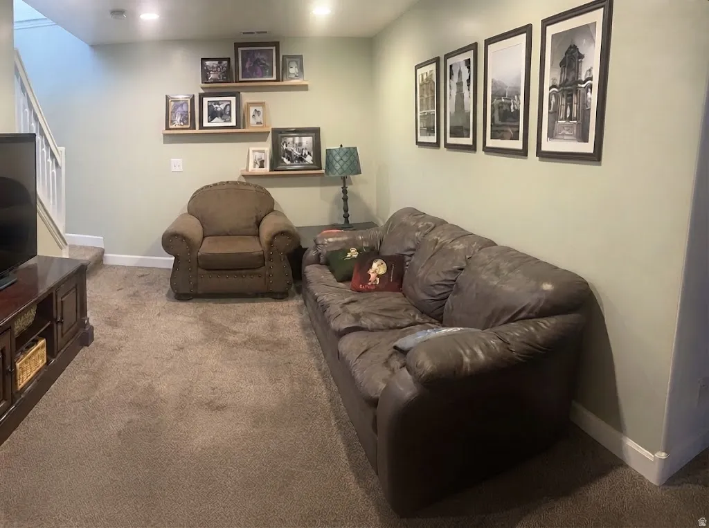 Recessed lighting illuminates the carpeted flooring and light-toned walls