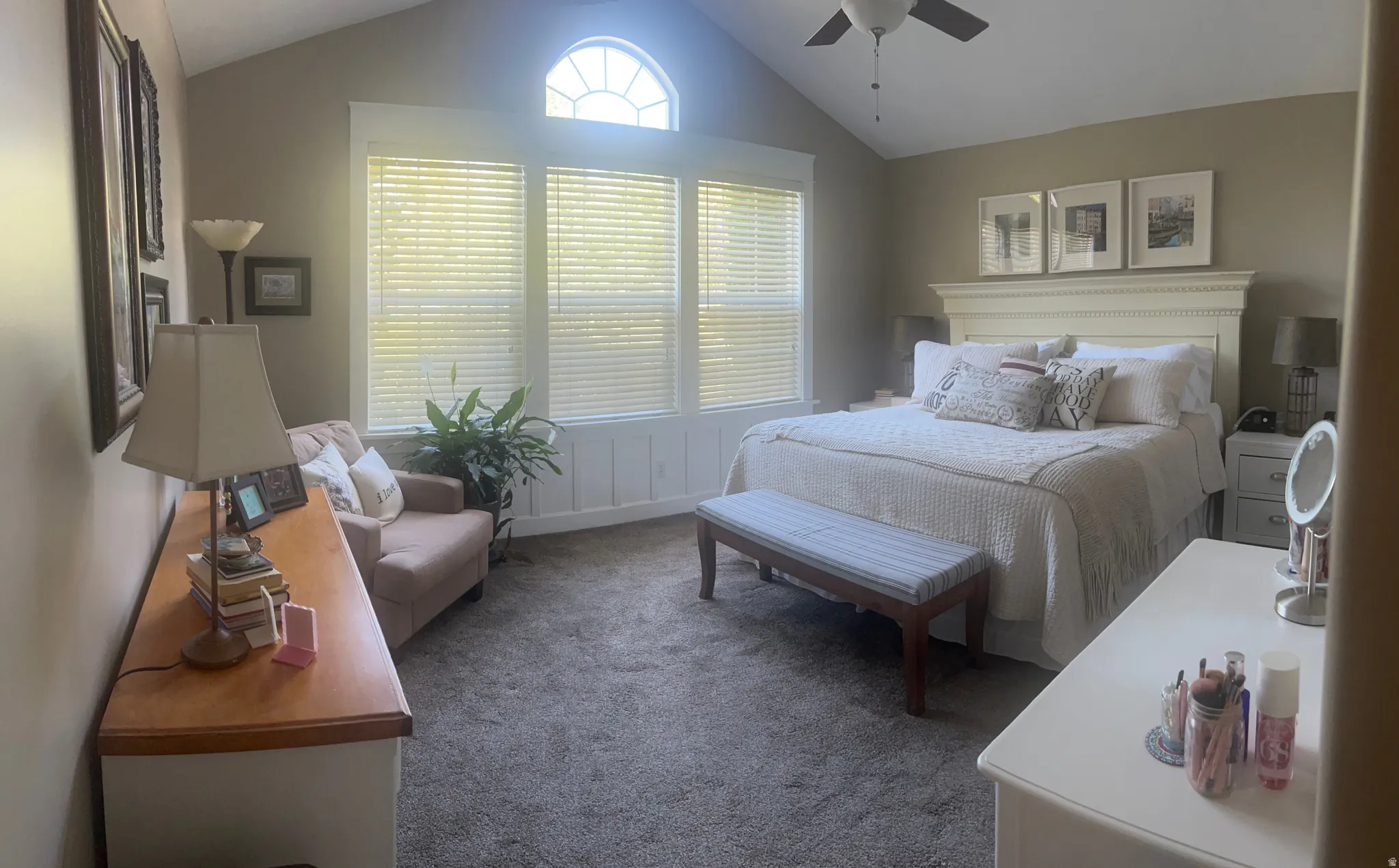 Vaulted ceiling with a ceiling fan, three large windows with blinds, a half-round transom window, and wainscoting