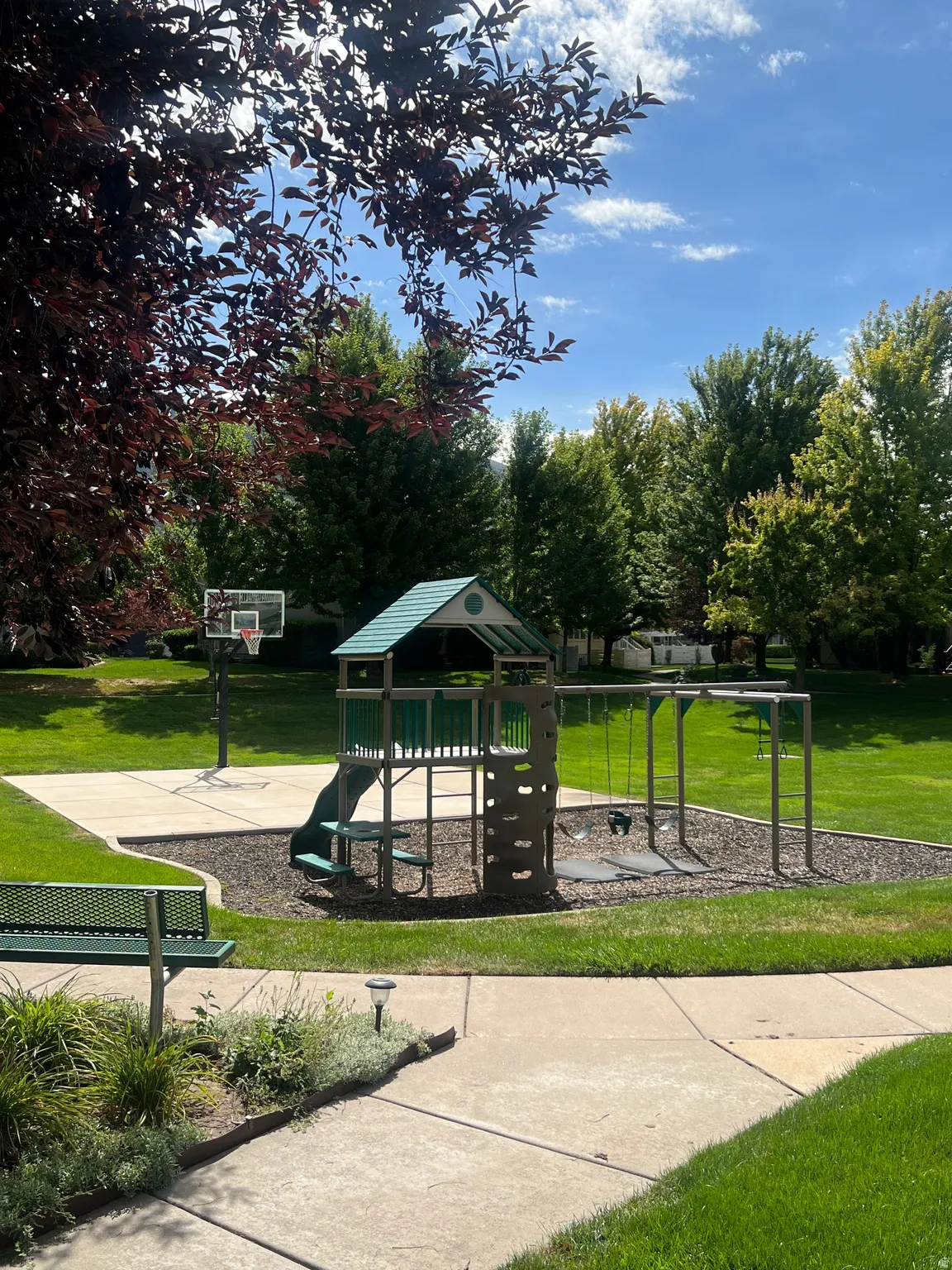 Recreational area with a playground structure, swing set, and basketball court