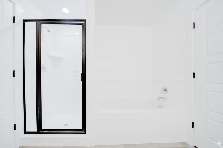 Walk-in shower with dark-framed glass enclosure, built-in shower shelving, and chrome fixtures