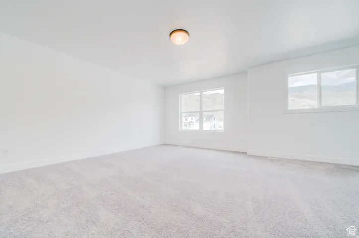 Spacious interior with neutral carpeting and multiple windows