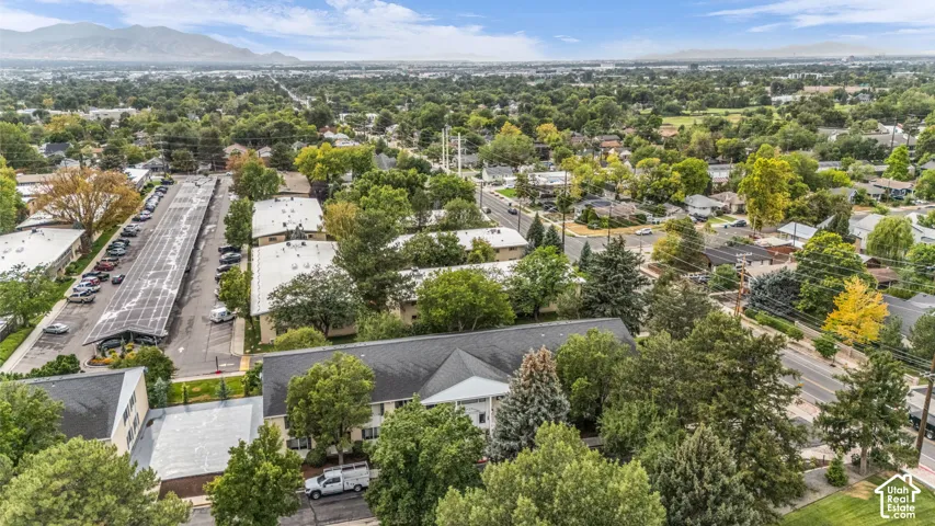 Aerial perspective showcasing multiple buildings, mature landscaping, and an extensive parking area with covered carports