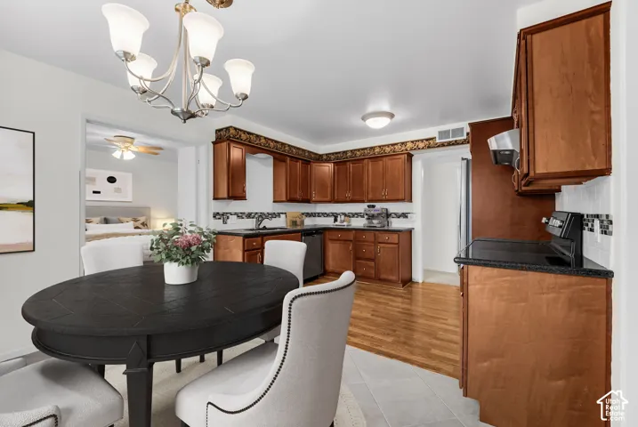 Kitchen featuring wood cabinetry, black countertops, and a tiled backsplash