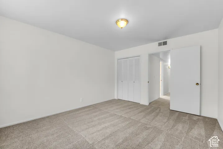 Neutral-toned carpeting, white walls, and a ceiling-mounted light fixture