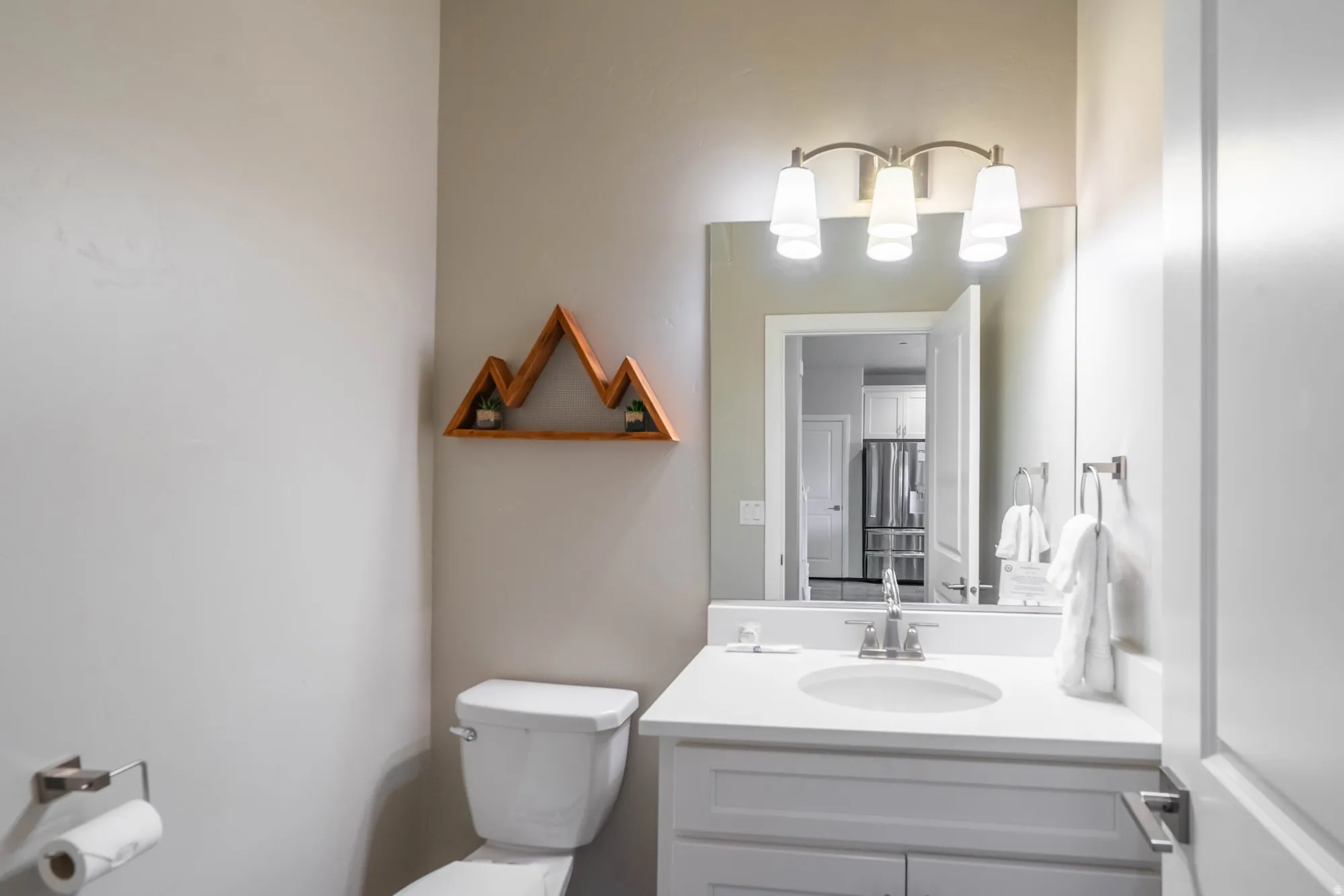 White vanity with a single basin sink, brushed nickel faucet, and integrated countertop