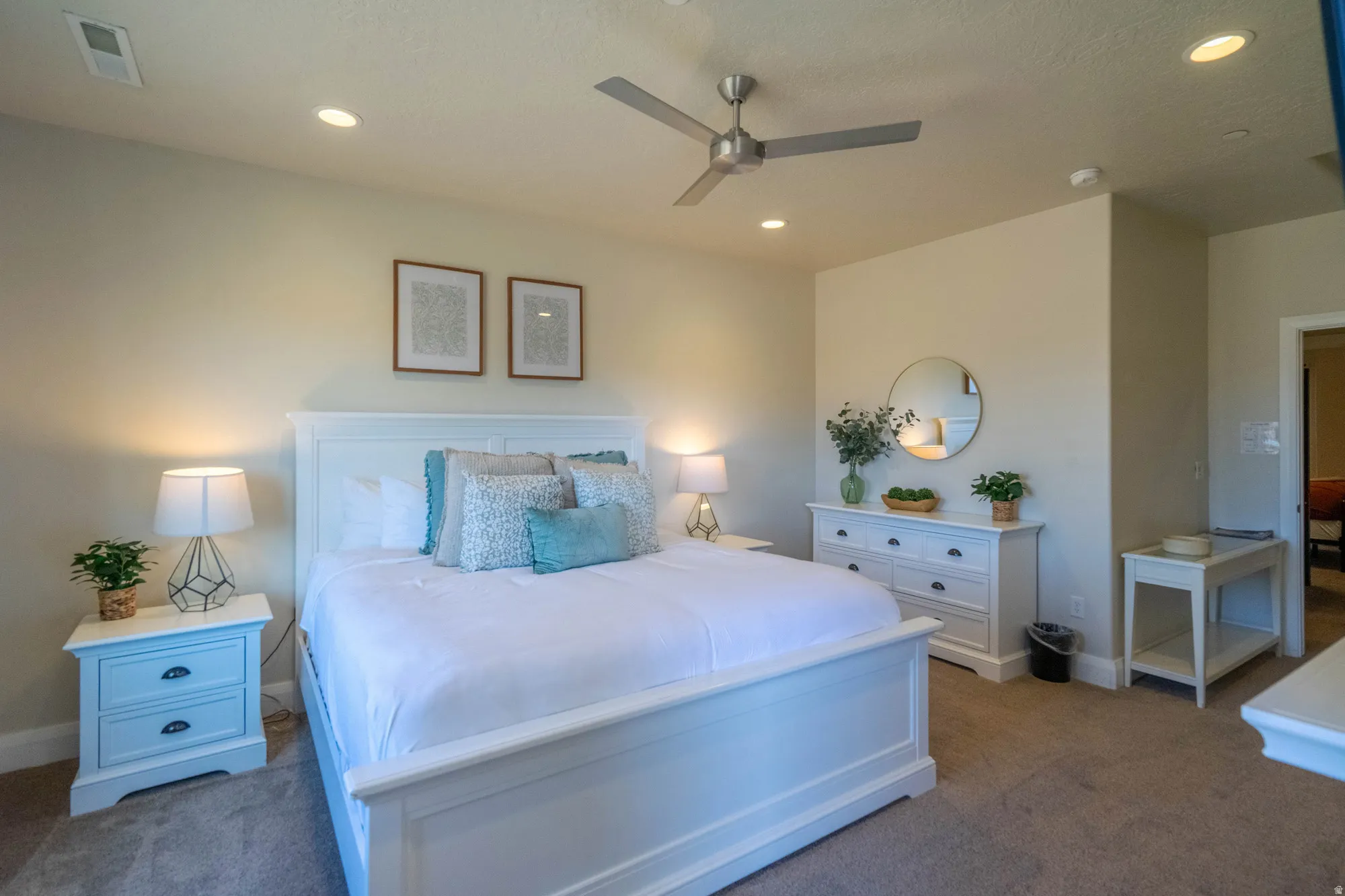 Recessed lighting, ceiling fan, carpet flooring, white painted walls, and white case goods