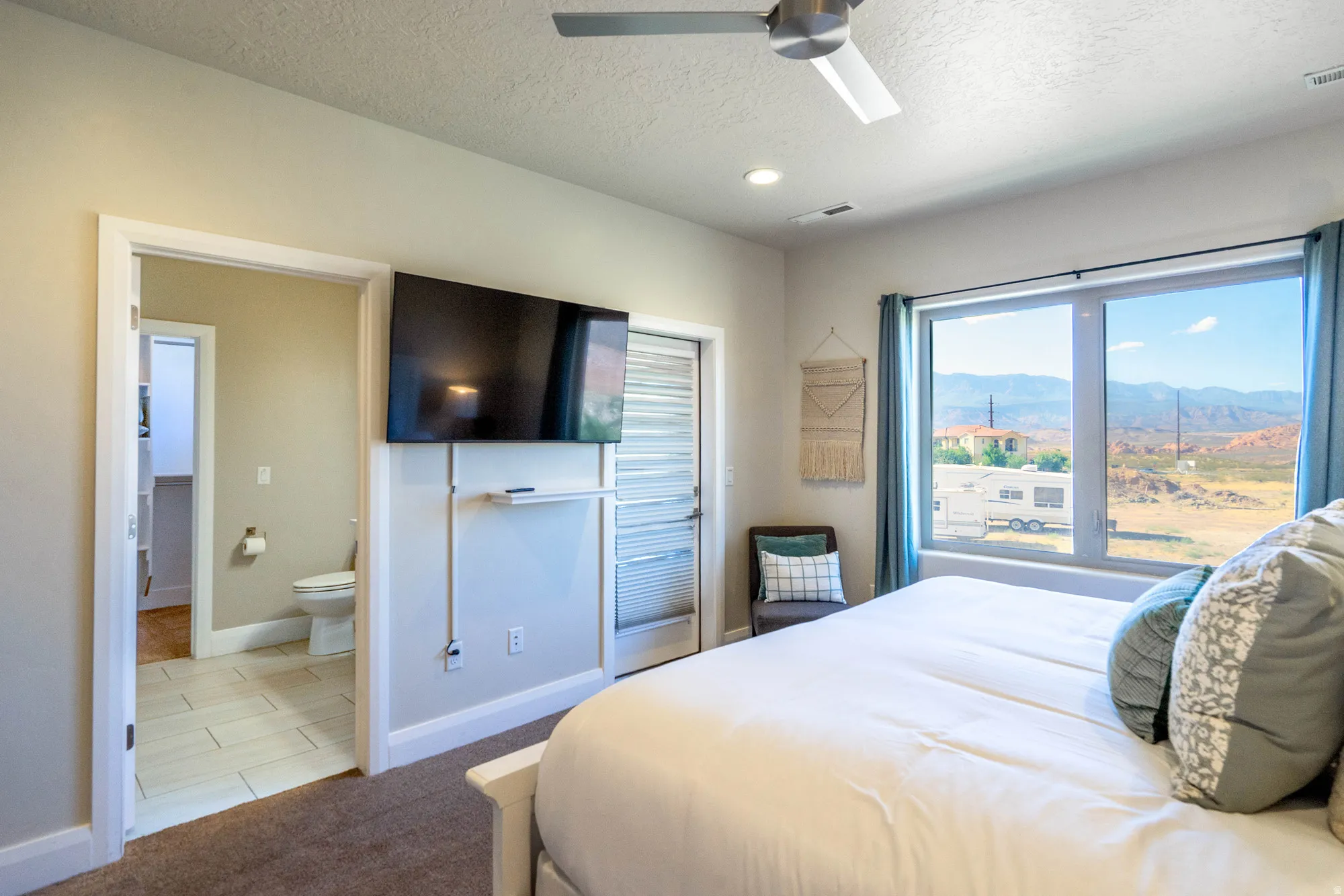 Recessed lighting, ceiling fan, expansive window, private exterior door, and a dedicated bathroom entrance