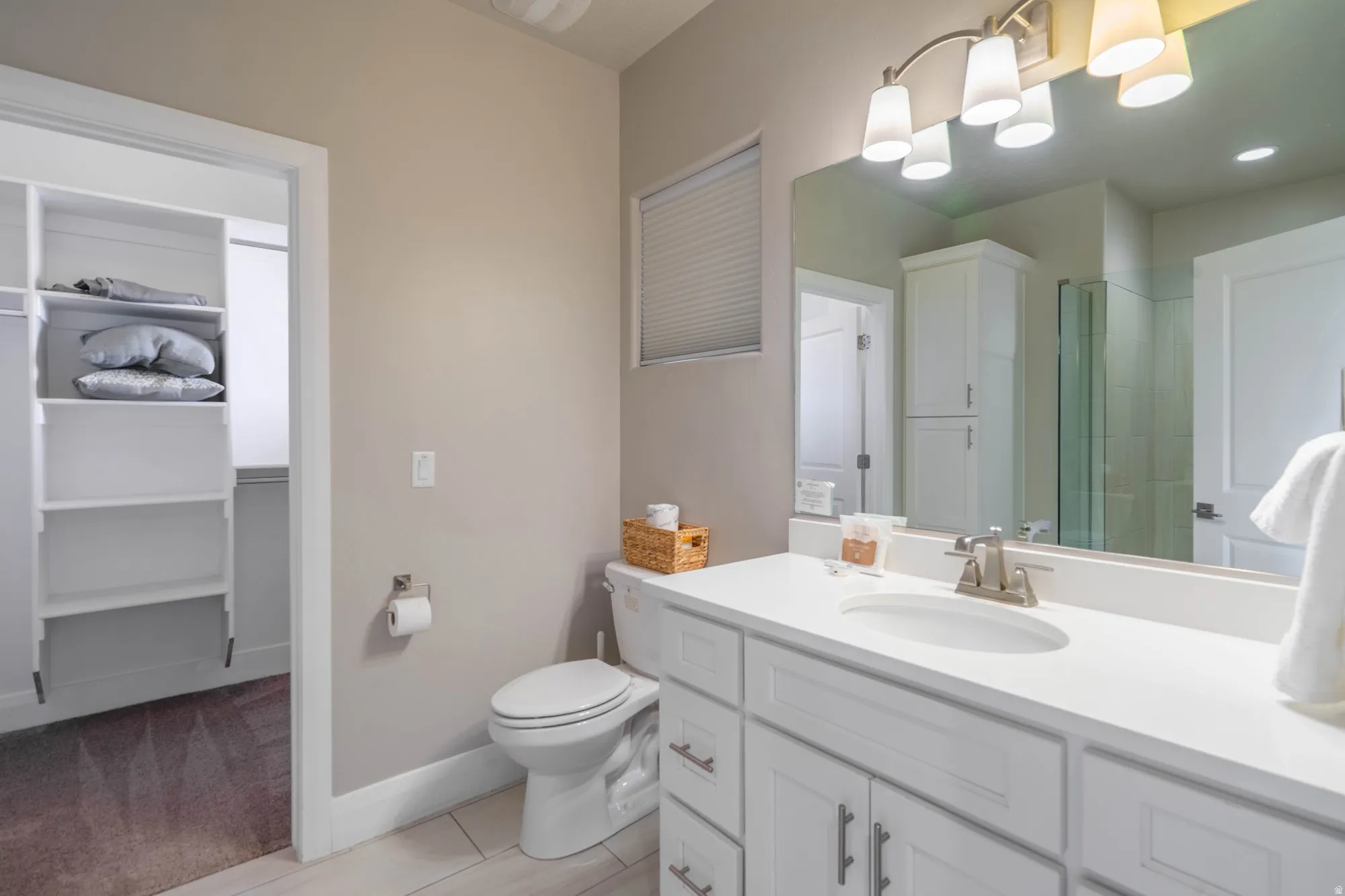 White vanity with brushed nickel hardware, integrated sink, and substantial countertop space