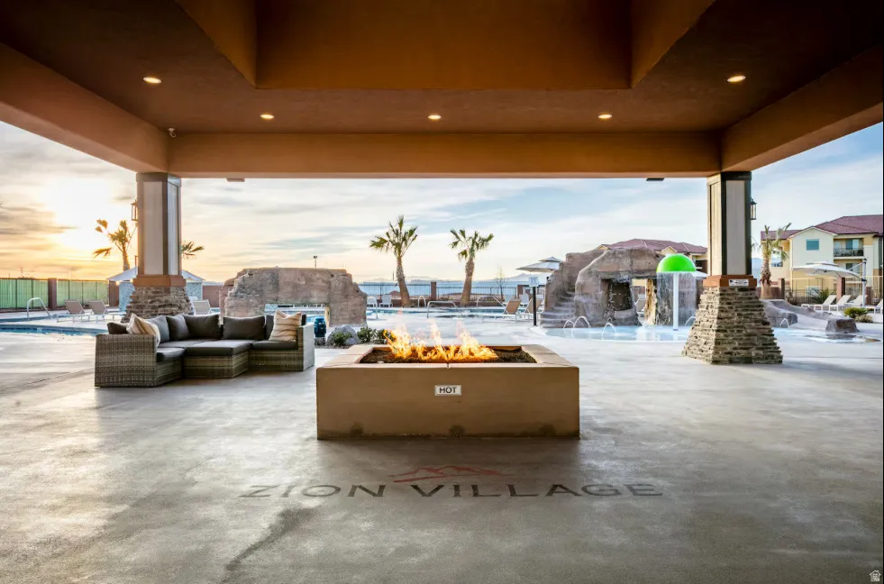 Covered outdoor patio with a concrete floor, built-in fire pit, and recessed lighting