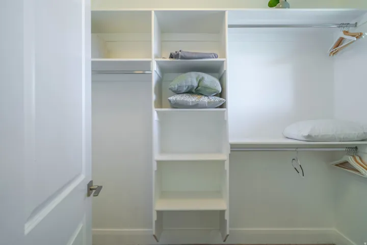 White closet system featuring built-in shelving and hanging rods