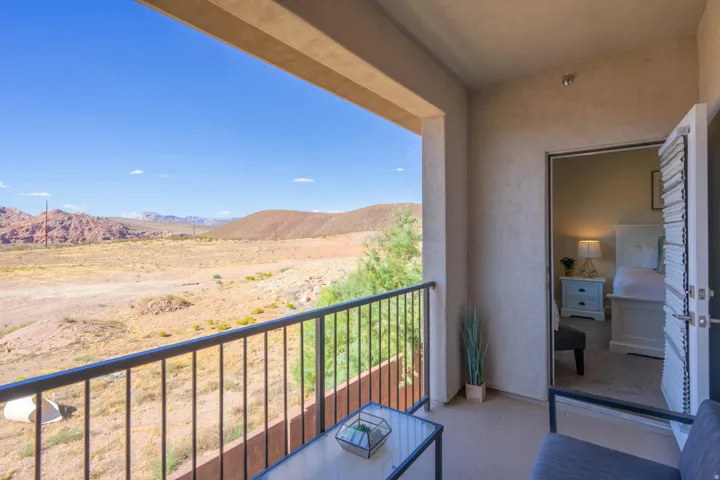 Outdoor balcony with wrought iron railing, concrete flooring, and direct access to an interior room