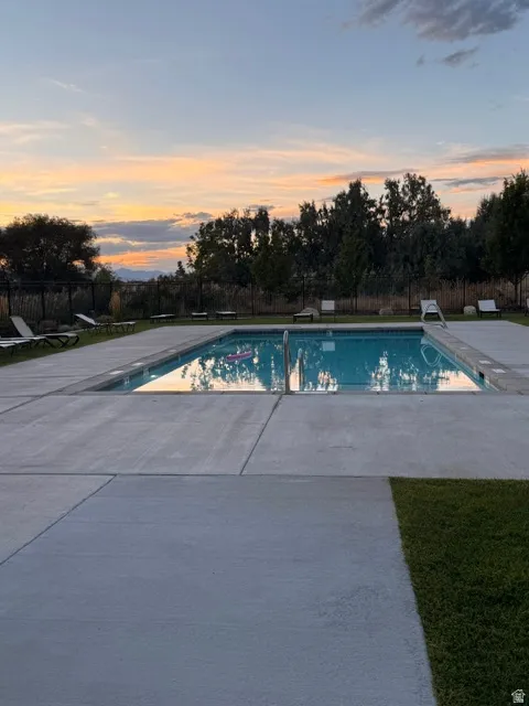 Outdoor swimming pool with concrete surround and adjacent lawn