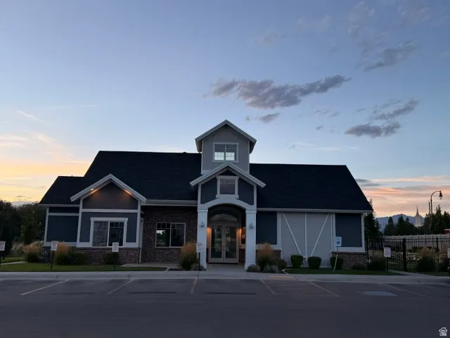 Modern facade featuring dark siding, brick accents, a gabled roofline, and an arched entry