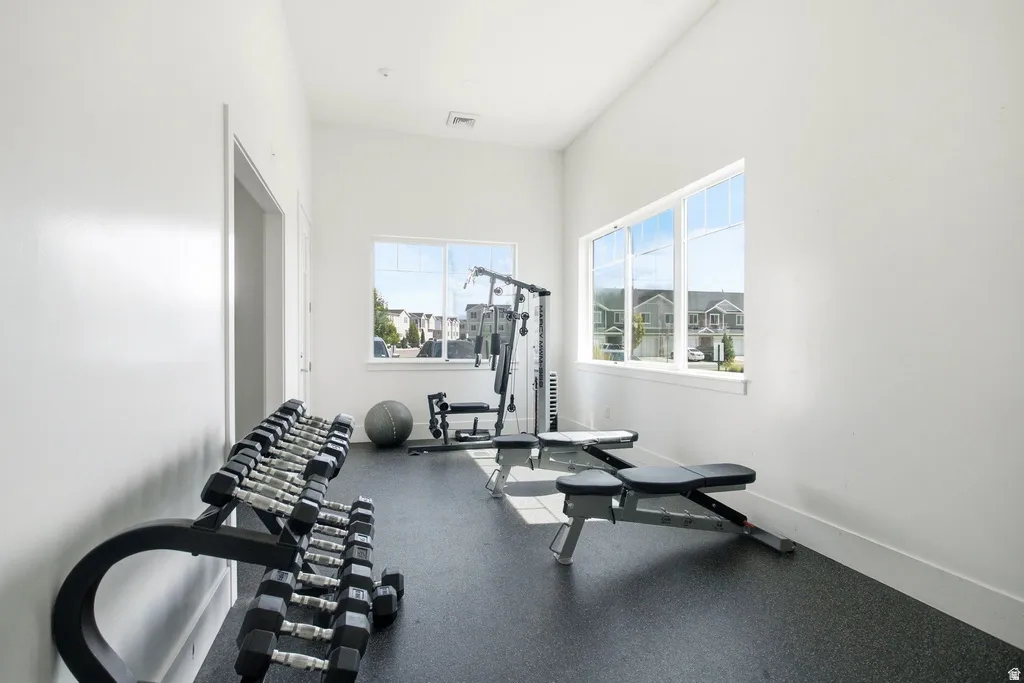 Bright room with multiple windows, white walls, and dark rubberized flooring