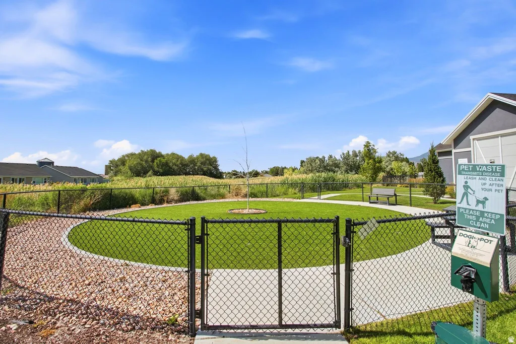 Fenced green space with a gravel perimeter and paved walking path