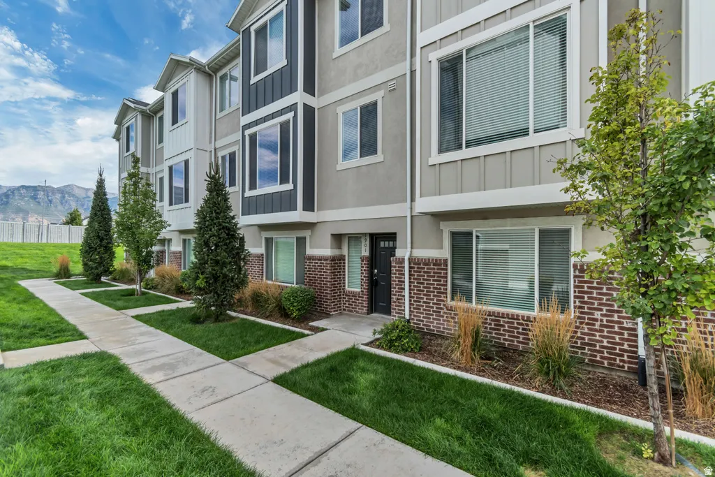 Exterior showcasing multi-story construction, brick lower-level facade, and vertical siding accents