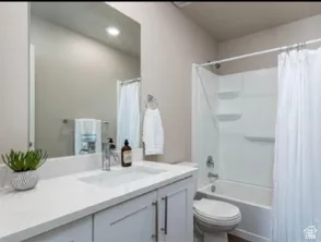 Built-in vanity with a single basin sink, white cabinetry, and a large wall-mounted mirror