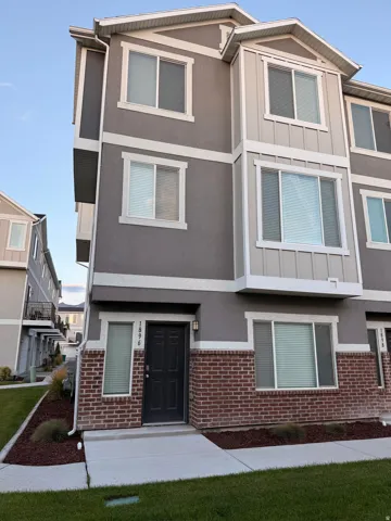 Multi-level townhouse with a stucco and brick exterior