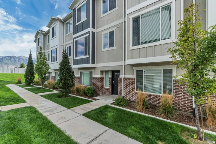 Exterior showcasing multi-story construction, brick lower-level facade, and vertical siding accents