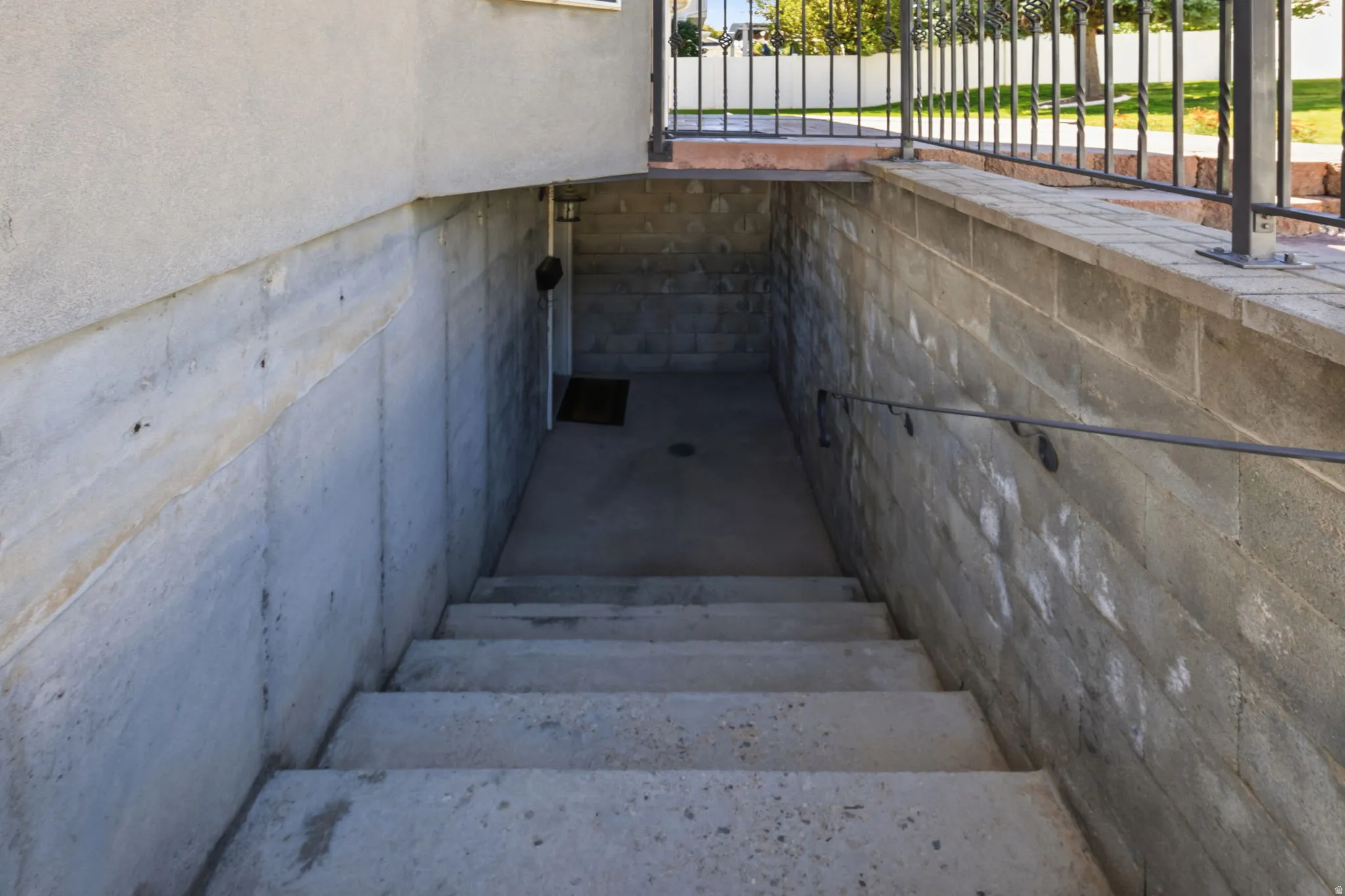 Concrete staircase descending to an exterior entry
