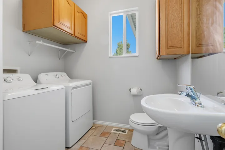 Ceramic tile flooring, pedestal sink, and overhead cabinetry