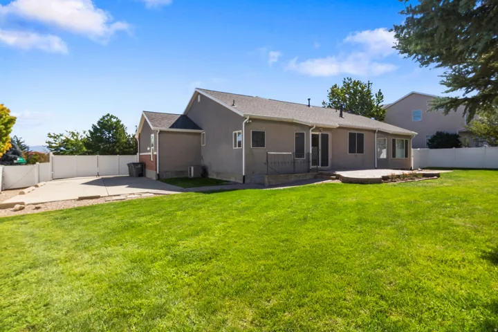 Expansive grassy yard with a paved patio area