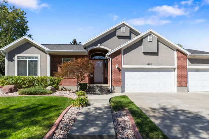 Stucco and brick exterior with a multi-car garage