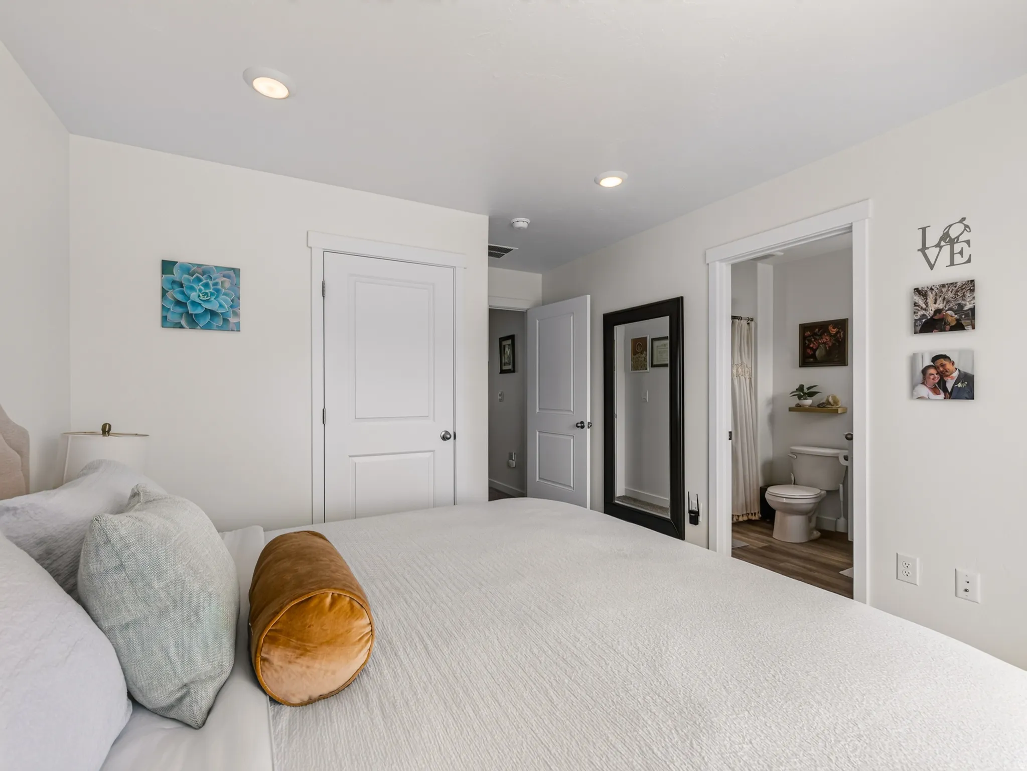 Recessed ceiling lighting, white interior doors, and wood-finish flooring in the bathroom