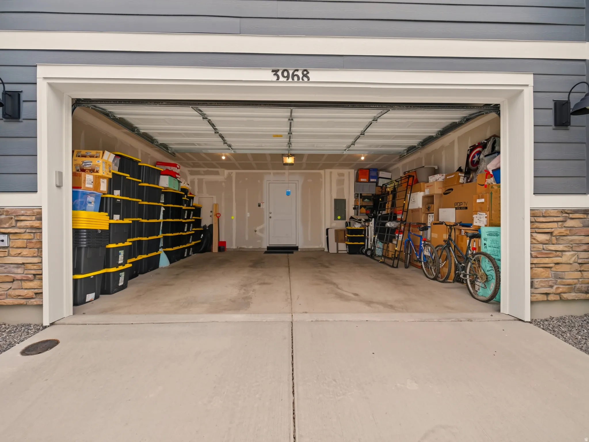 Attached two-car garage with a concrete driveway and stacked stone accents