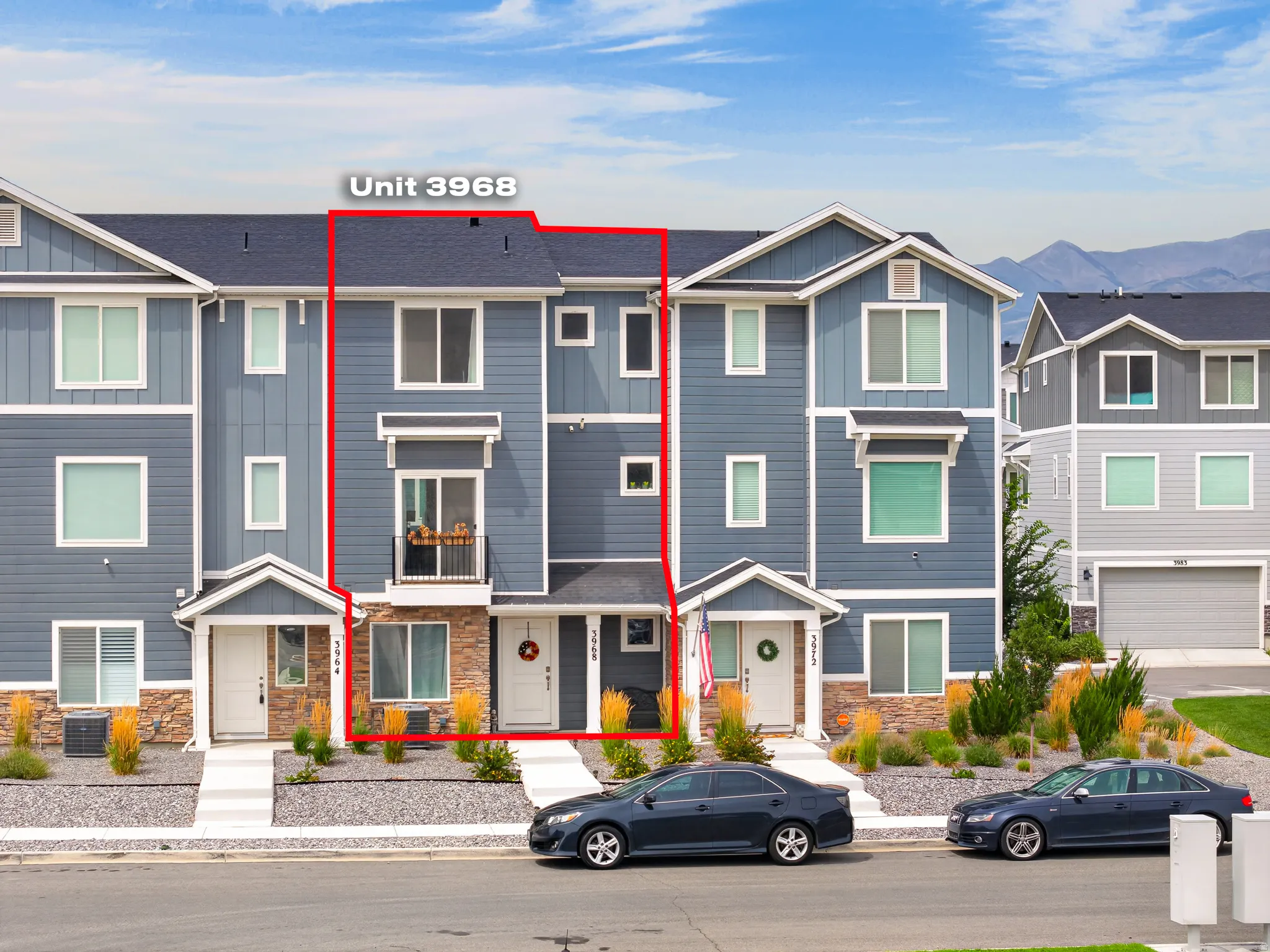 Modern townhome exterior with mixed material siding, stone accents, and a covered front entry