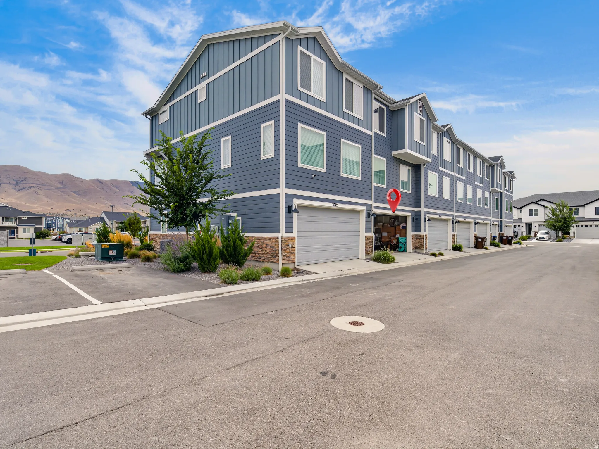 Multi-level residential building featuring horizontal siding and stone veneer accents