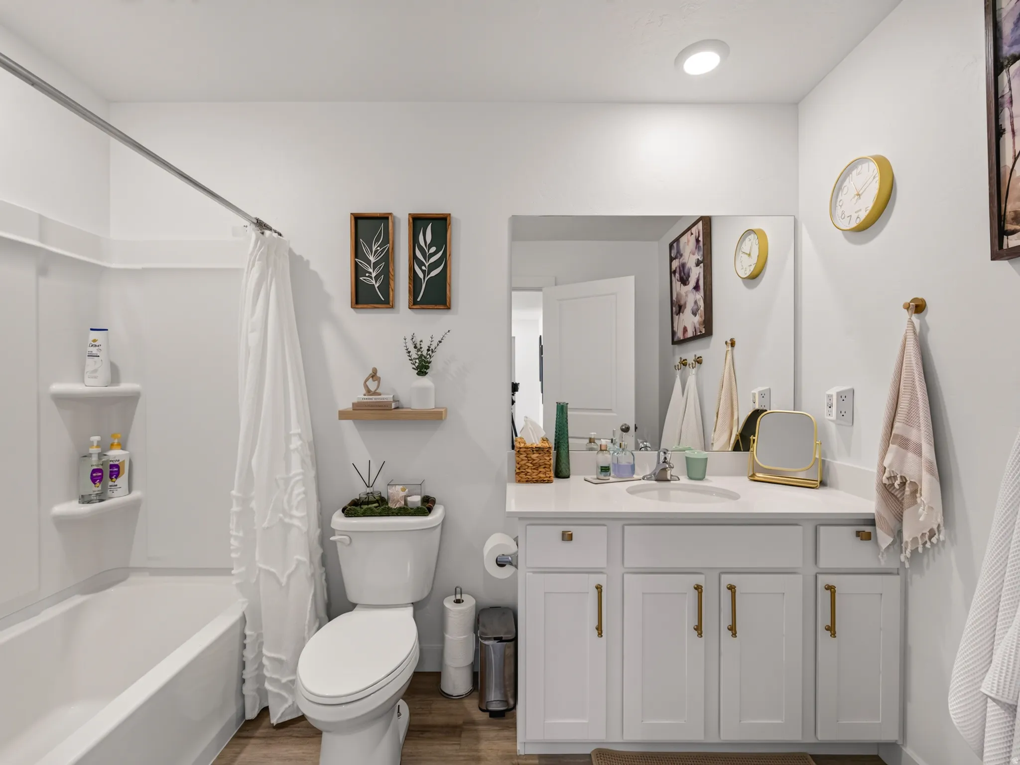 White vanity with gold-finish hardware, single basin sink, and counter space