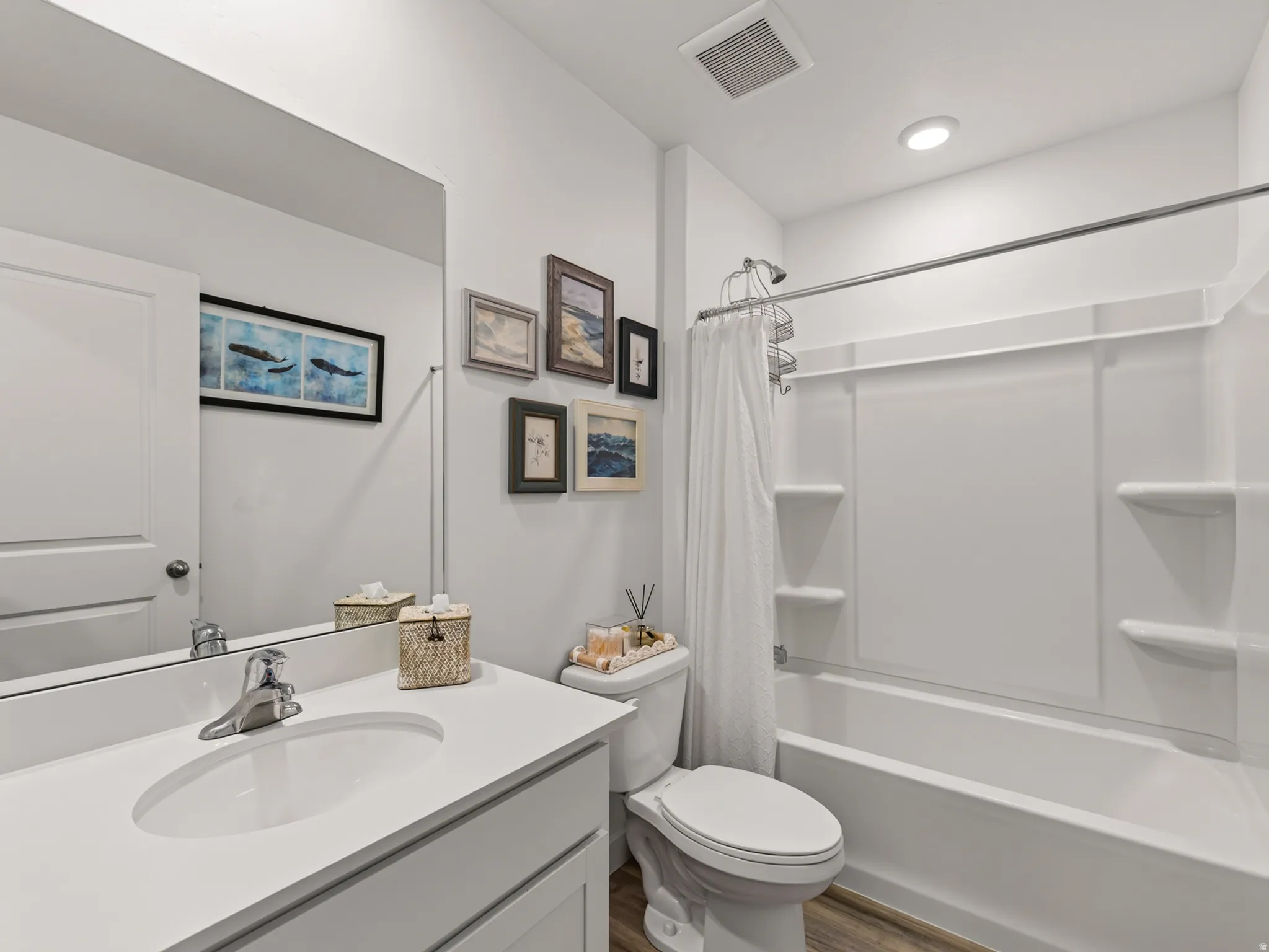 White vanity with an integrated sink, polished chrome faucet, and expansive mirror