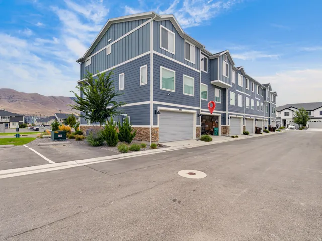 Multi-level residential building featuring horizontal siding and stone veneer accents