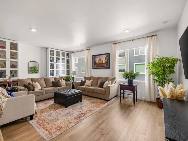 Recessed lighting, wood-finish flooring, two built-in glass-front display cabinets, and large windows