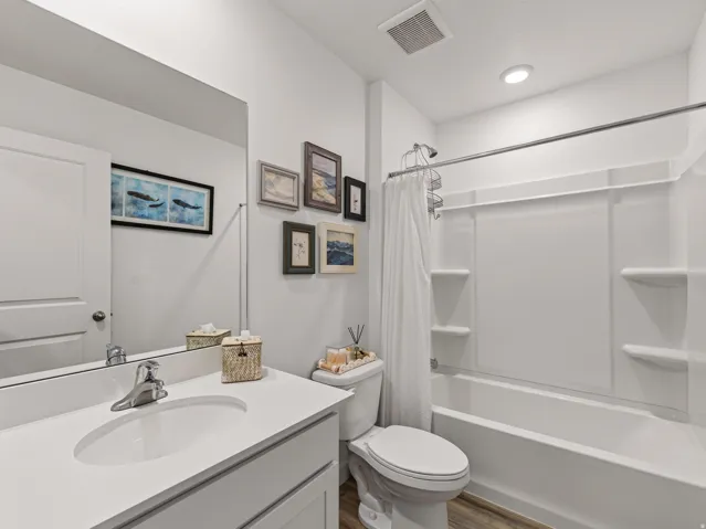 White vanity with an integrated sink, polished chrome faucet, and expansive mirror
