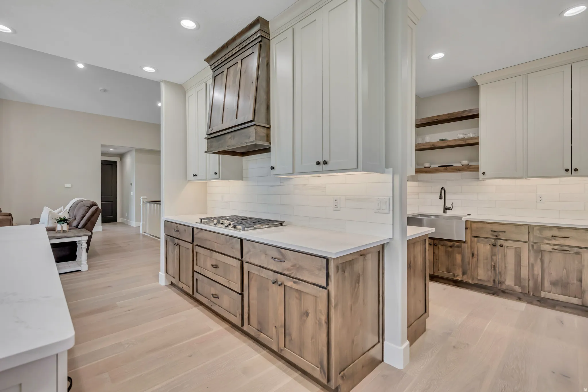 Kitchen featuring two-tone cabinetry, wood-finish flooring, white subway tile backsplash, and stainless steel appliances
