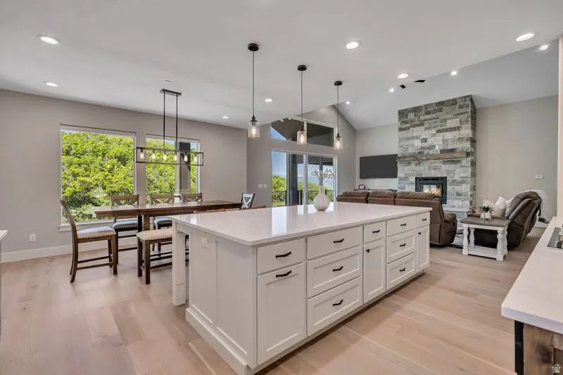 Spacious open-concept interior featuring light wood-finish flooring and a vaulted ceiling
