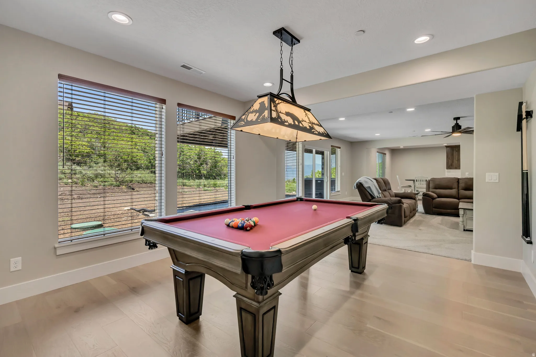 Recessed lighting, wood-finish flooring, and multiple windows with blinds