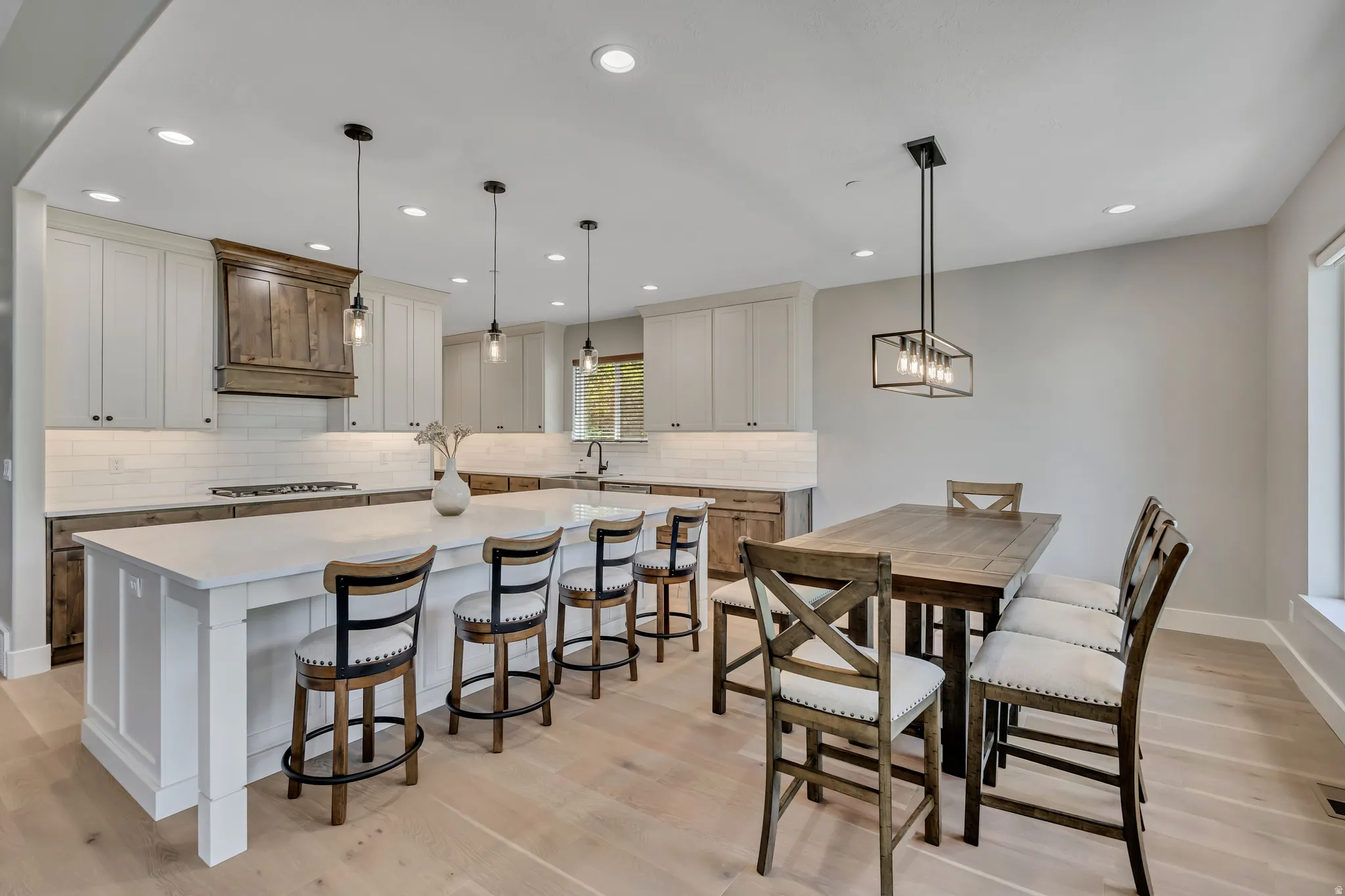 Kitchen with light-toned shaker cabinetry and a wood-finish hood