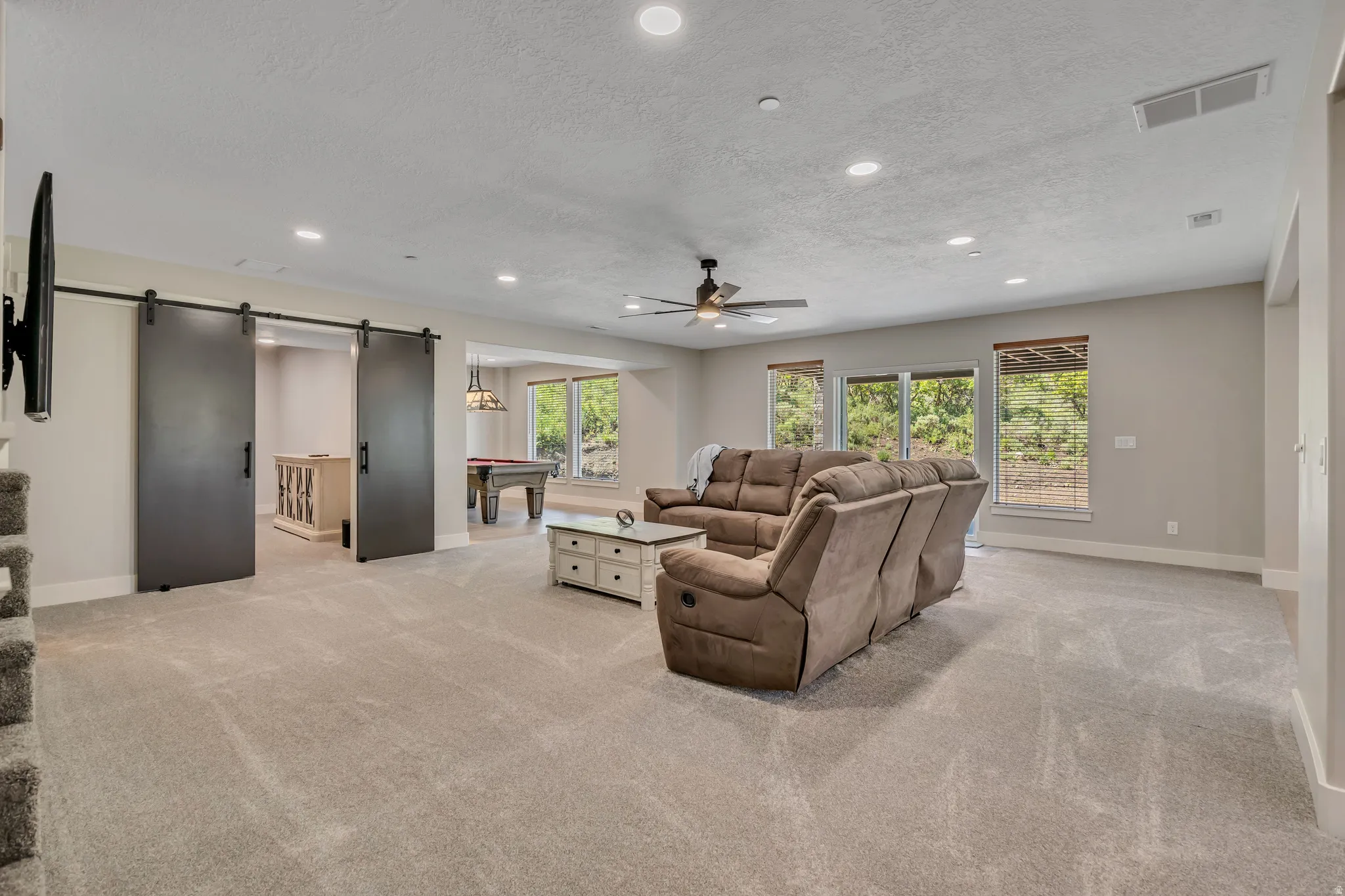 Spacious living area featuring recessed lighting, a ceiling fan, and carpeted flooring