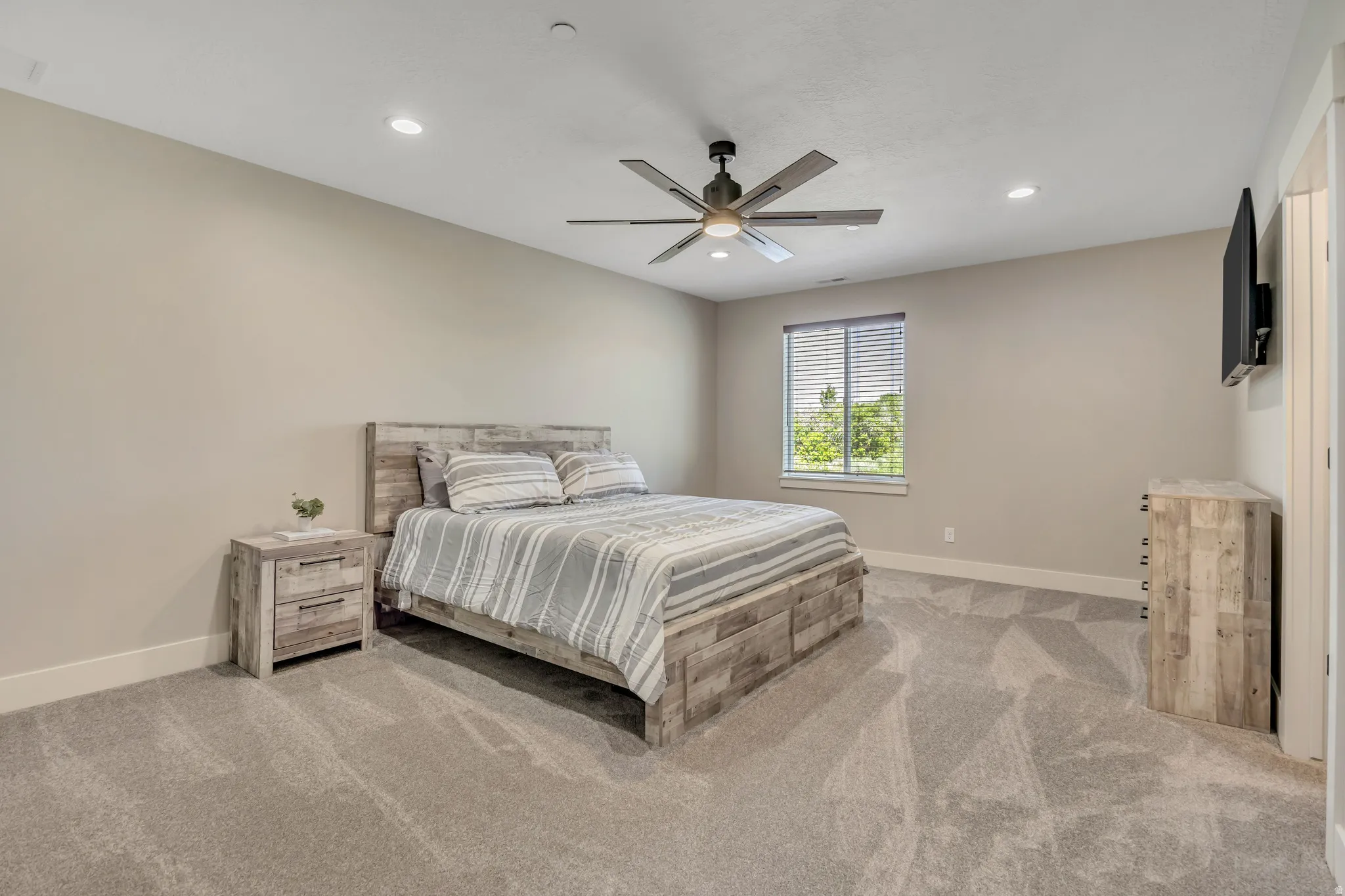 Recessed ceiling lighting, ceiling fan, window with horizontal blinds, neutral wall paint, and gray carpet flooring