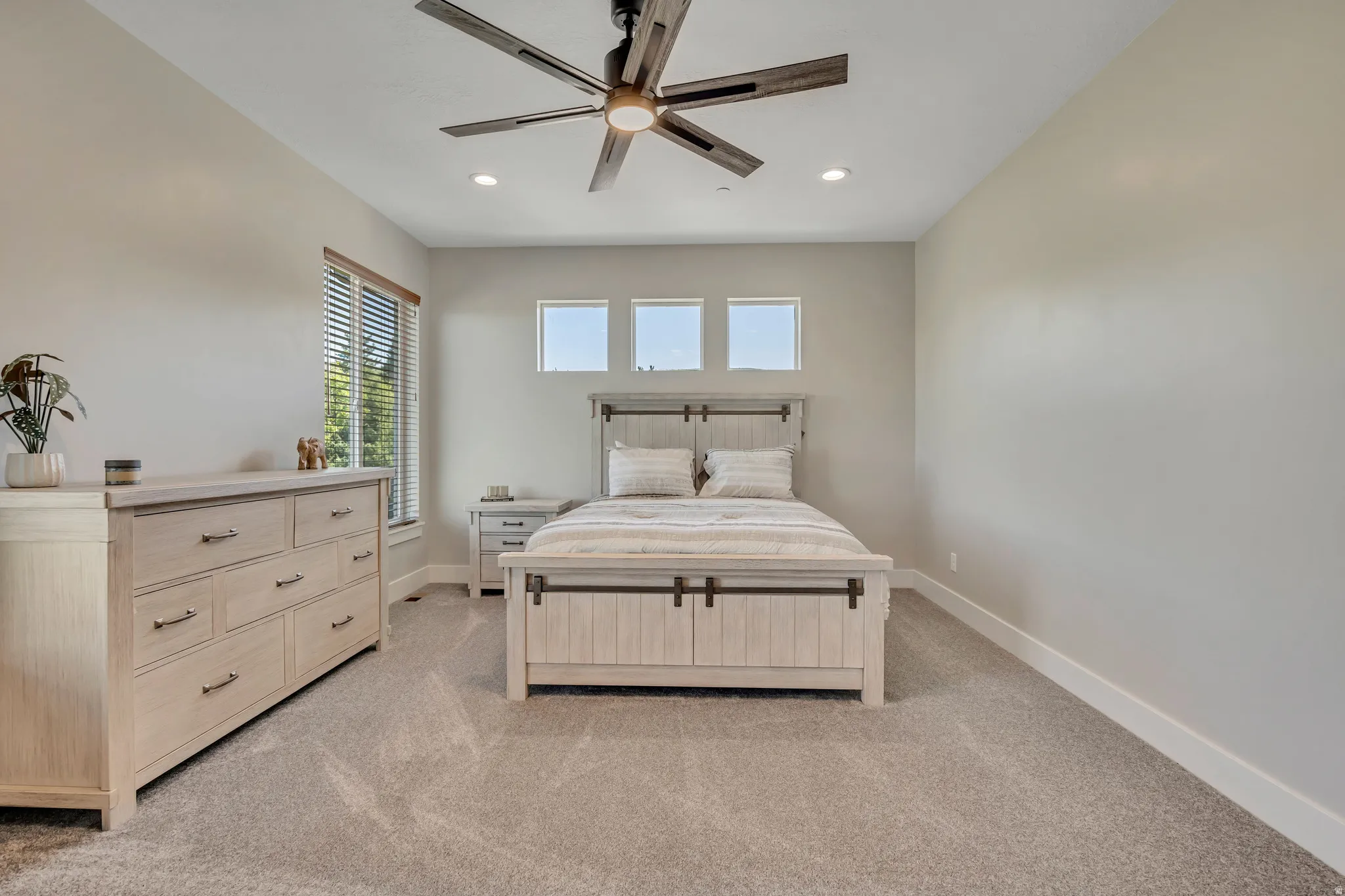 Recessed lighting, ceiling fan with wood-finish blades, and multiple windows with blinds