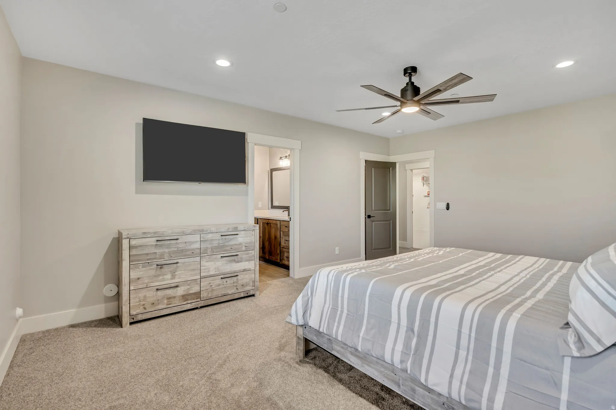 Recessed lighting, ceiling fan, carpeted flooring, and a wall-mounted television
