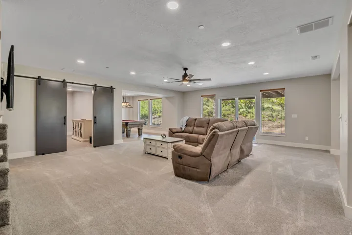 Spacious living area featuring recessed lighting, a ceiling fan, and carpeted flooring