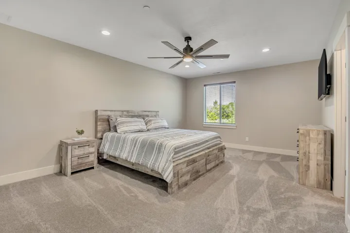 Recessed ceiling lighting, ceiling fan, window with horizontal blinds, neutral wall paint, and gray carpet flooring